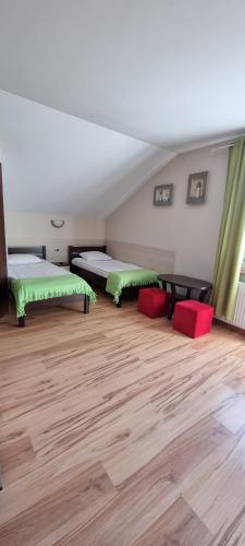 a room with two beds with green and red chairs at Pokoje w Zielonym Domku in Łazy