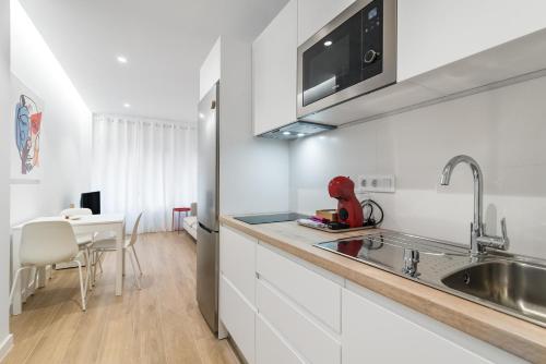 a kitchen with white cabinets and a sink at Home2Book Cozy & Chic Apartment near the Beach in La Garita