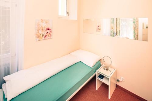 Cette petite chambre comprend un lit et une petite table. dans l'établissement Paladina Hotel, à Pura