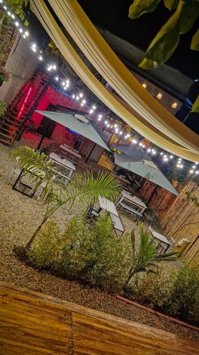 a group of tables and chairs with umbrellas and lights at Urban Hostal San Gil- Piscina Restaurante Bar in San Gil