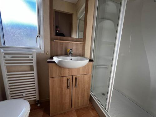 een badkamer met een wastafel en een douche bij Lovely Caravan With Decking At Cherry Tree Holiday Park In Norfolk Ref 70528c in Great Yarmouth