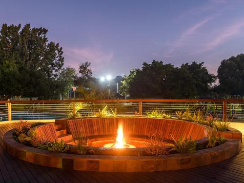 a fire pit with a bench in front of it at Dikhololo in Brits