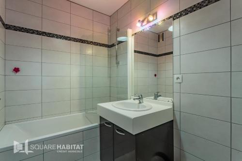 une salle de bain blanche avec un lavabo et une baignoire dans l'établissement HARISTEGUY-Bien moderne avec confort 700m des commerces, à Saint-Jean-de-Luz