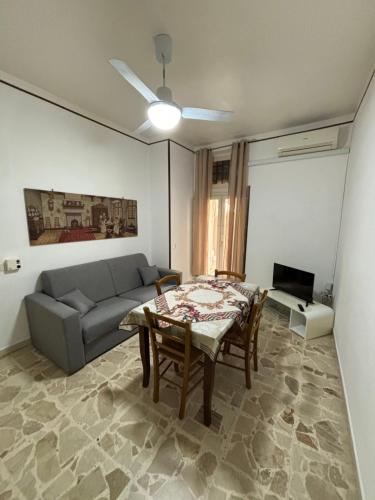 ein Wohnzimmer mit einem Sofa, einem Tisch und Stühlen in der Unterkunft November House Cefalù in Cefalú