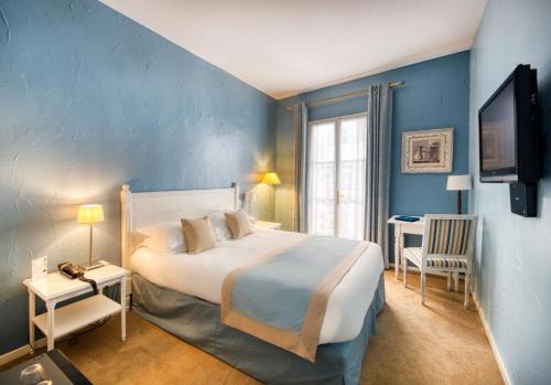 - une chambre avec un grand lit et un mur bleu dans l'établissement Hotel d'Aragon, à Montpellier