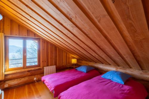 two beds in a room with a wooden ceiling at Chalet l'Epicurien - Au calme avec grand jardin in Saint-Martin-du-Puy