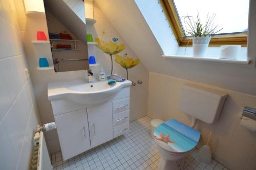 クックスハーフェンにあるHaus Mühlentrift Döseのバスルーム(洗面台、トイレ付)、窓が備わります。