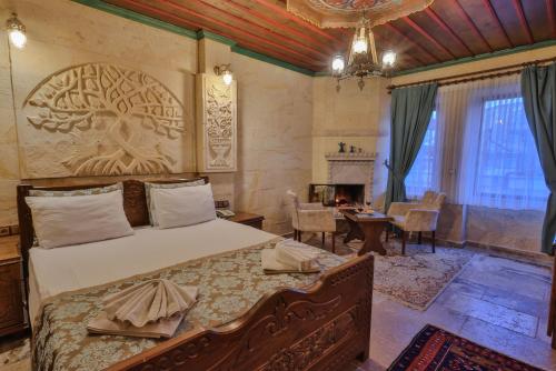 sypialnia z łóżkiem z rzeźbionym drzewem na ścianie w obiekcie Feel Cappadocia Stone House w Göreme