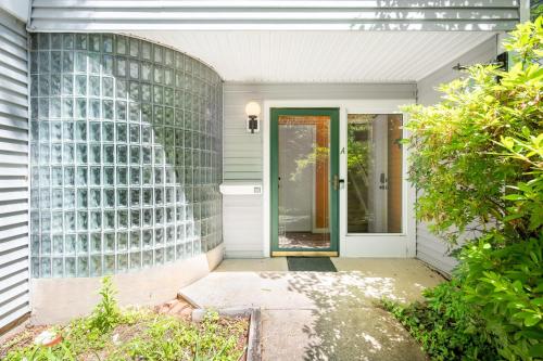 a front door of a house with a glass wall at Retro Loft steps from Duke in Durham