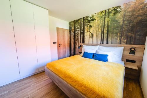a bedroom with a bed with a painting on the wall at Hygge Apartments in Rožmberk nad Vltavou