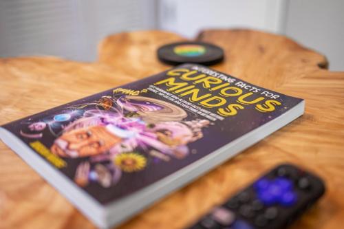 a book sitting on a table next to a remote control at Retro Loft steps from Duke in Durham