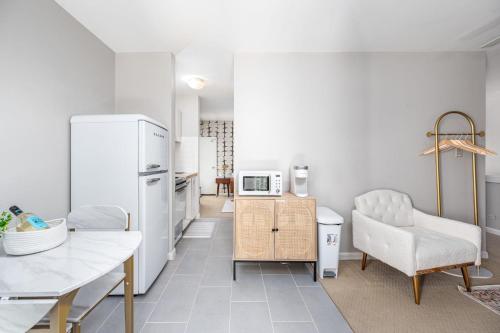 a kitchen with a refrigerator and a table and a chair at Retro Loft steps from Duke in Durham