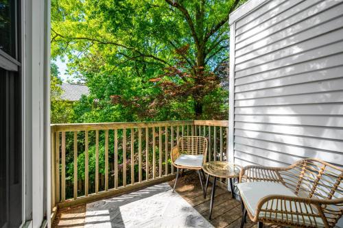 a porch with two chairs and two chairs on it at Retro Loft steps from Duke in Durham