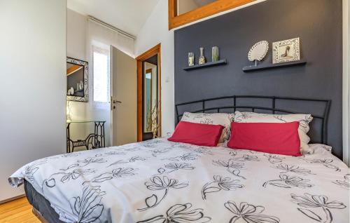 una camera con un letto con due cuscini rossi di Nice Home In Fazana With Wifi a Fažana