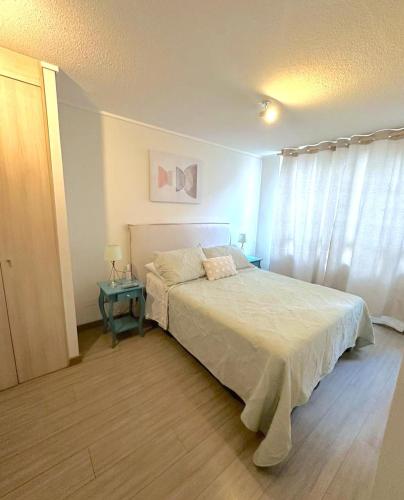 1 dormitorio con cama blanca y mesa en Central y con todas las comodidades 2, en Santiago