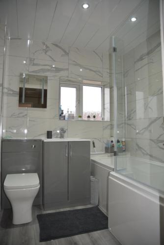 a white bathroom with a toilet and a sink at Peaceful Waterfront Apartment, Private Parking, Hull Marina in Hull