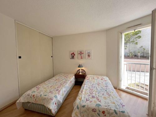 1 dormitorio con 2 camas y ventana en Appartement Saint-Raphaël, 3 pièces, 4 personnes - FR-1-226A-146, en Port Santa-Lucia