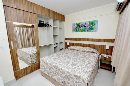 a small bedroom with a bed and a mirror at Lacqua diRoma com Parque Aquático e Cozinha in Caldas Novas
