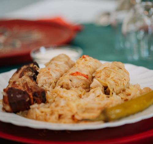a plate of food with a pickle on a table at Telegdy Homes in Praid