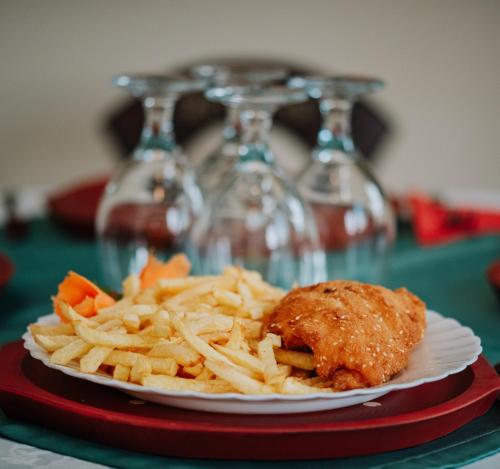 a plate of food with meat and fries on a table at Telegdy Homes in Praid