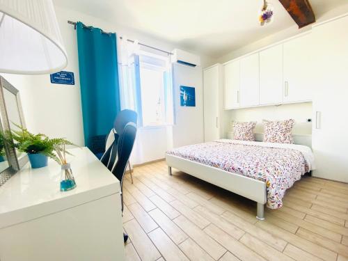 une petite chambre avec un lit et un bureau dans l'établissement MAGNIFIQUE APPART 102 m2 AU BORD DE L'EAU HYPER CENTRE, à Sète