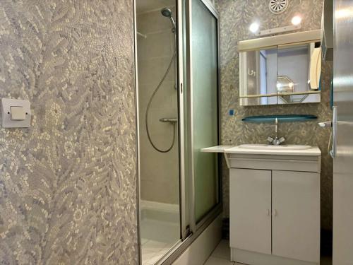 une salle de bain avec une douche, un lavabo et un miroir dans l'établissement Maison 4 pièces avec terrasse et parking privé, proche plage et commerces à Argelès-sur-Mer - FR-1-225-450, à Argelès-sur-Mer