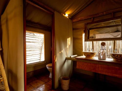 a bathroom with a toilet and a window at Evolve Back Kalahari in Central Kalahari