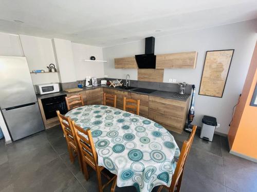 Il comprend une cuisine équipée d'une table et de chaises. dans l'établissement Appartement spacieux avec terrasse, solarium, parking et piscine - FR-1-723-5, au Cap d'Agde