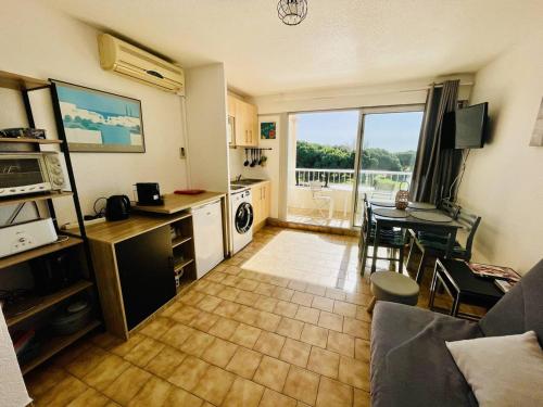 un salon avec une cuisine et une salle à manger dans l'établissement Studio cabine climatisé proche plage et loisirs avec piscine - FR-1-723-112, au Cap d'Agde