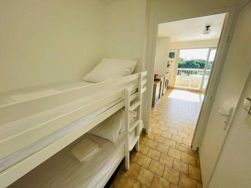 Cette chambre dispose de lits superposés et d'un couloir. dans l'établissement Studio cabine climatisé proche plage et loisirs avec piscine - FR-1-723-112, au Cap d'Agde