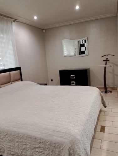 a bedroom with a white bed and a mirror at Apartment at Kvitka Polonyny in Solochin