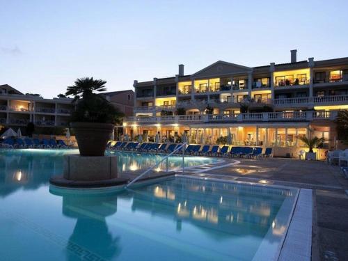 un hôtel avec une piscine devant un immeuble dans l'établissement Studio cabine avec vue mer, piscine et parking à Cannes la Bocca - FR-1-609-93, à Cannes