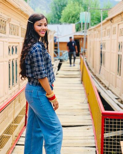 a woman is standing on a platform next to a train at Pasadona Floating Houseboat in Srinagar