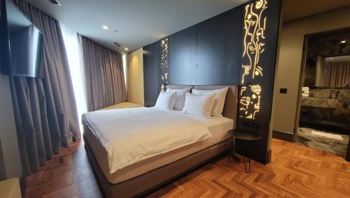 a bedroom with a large bed with a black headboard at Arka Art Hotel in Tirana