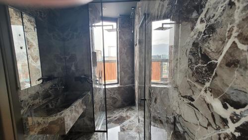 a bathroom with a shower with a glass door at Arka Art Hotel in Tirana