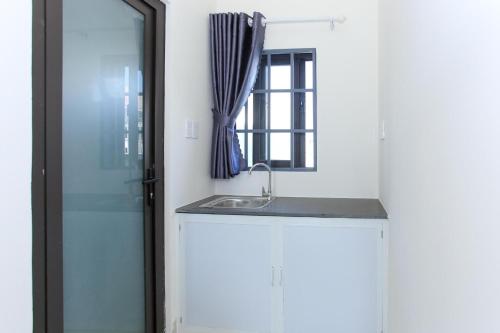 a bathroom with a sink and a window at OYO 1064 Phat Tai Hotel And Apartment in Da Nang