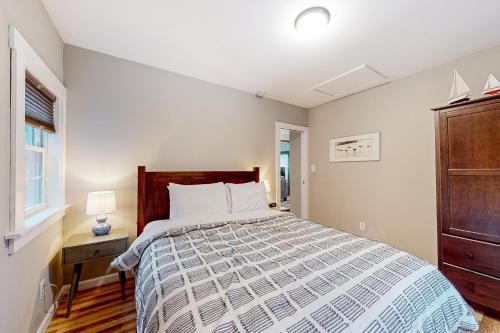 a bedroom with a bed and a window at Blue Button Cottage in Gouldsboro