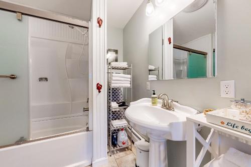 a white bathroom with a sink and a shower at Blue Button Cottage in Gouldsboro