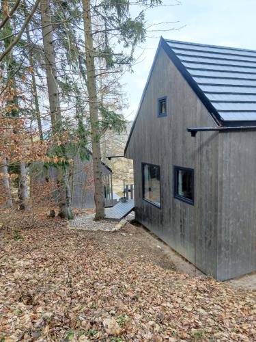 a gray house with a gambrel roof at Slow Huts in Miedzygorze