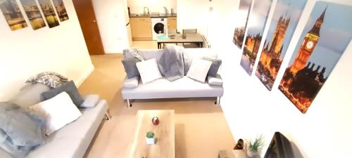 a living room with a white couch and a table at 2 Bed Crawley Apt - Near Gatwick in Crawley