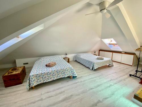 a attic bedroom with two beds and a window at Duplex Ti Rooftop spa et vue mer in Saint-Leu