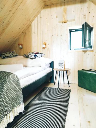 a bedroom with two beds in a wooden wall at Slow Huts in Miedzygorze