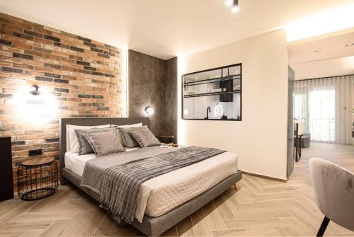 a bedroom with a bed and a brick wall at Almasi Luxury Suites Marquise in Alexandroupoli