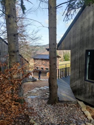 a person standing on a wooden deck next to a building at Slow Huts in Miedzygorze