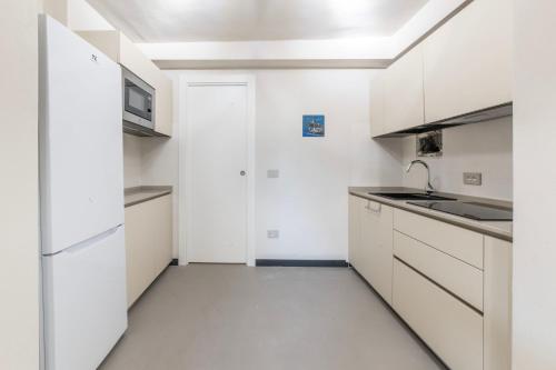 a white kitchen with a sink and a refrigerator at Mirabel Apartments Moneglia - Cinque Terre in Moneglia
