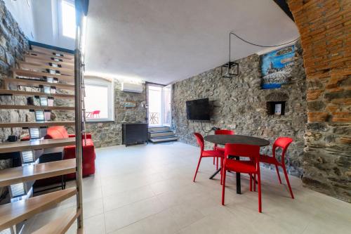 a dining room with a table and red chairs at Mirabel Apartments Moneglia - Cinque Terre in Moneglia