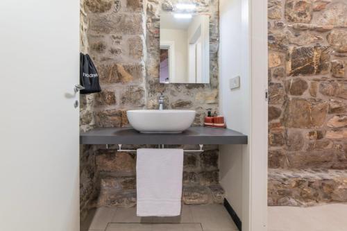 a bathroom with a sink and a stone wall at Mirabel Apartments Moneglia - Cinque Terre in Moneglia