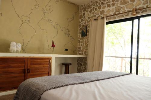 Nimá的住宿－Casa Ixtzá，卧室配有一张床,墙上有地图