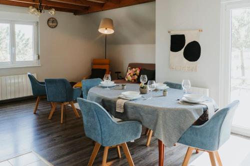 a dining room with a table and blue chairs at Maison à la campagne 6 personnes in Zutzendorf