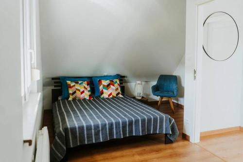 a bedroom with a bed and a blue chair at Maison à la campagne 6 personnes in Zutzendorf